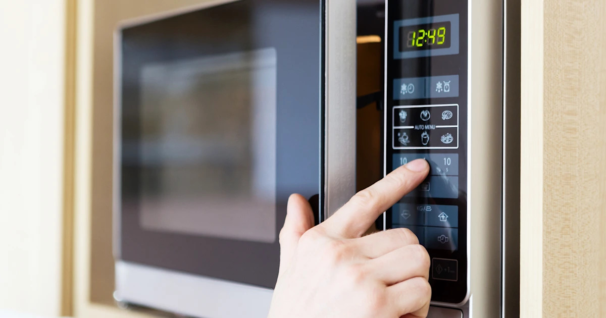 ấn nút điều khiển trên lò vi sóng